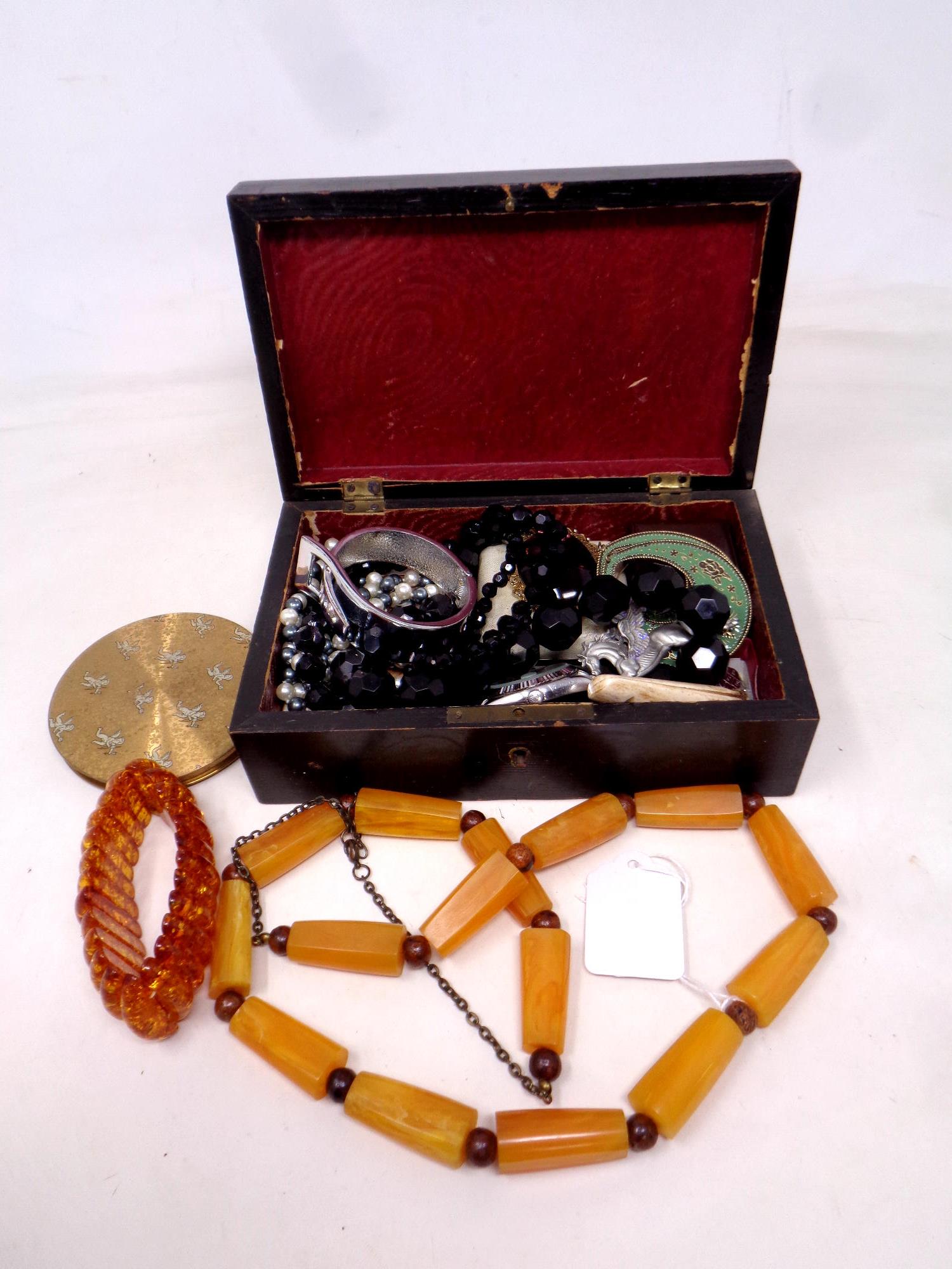 A lacquered box containing costume jewellery, beaded necklace etc.