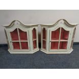 A pair of cream and gilt wall cabinets