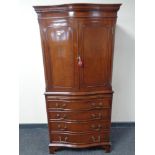 A reproduction mahogany serpentine fronted drinks cabinet