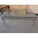 A rectangular glass topped coffee table on metal base