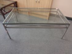A rectangular glass topped coffee table on metal base