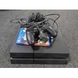 A Sony Playstation 4 with game and controllers