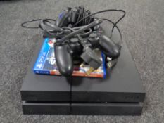 A Sony Playstation 4 with game and controllers