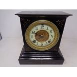 A 19th century painted metal mantel clock with brass and enamelled dial