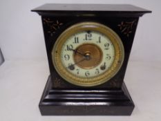 A 19th century painted metal mantel clock with brass and enamelled dial