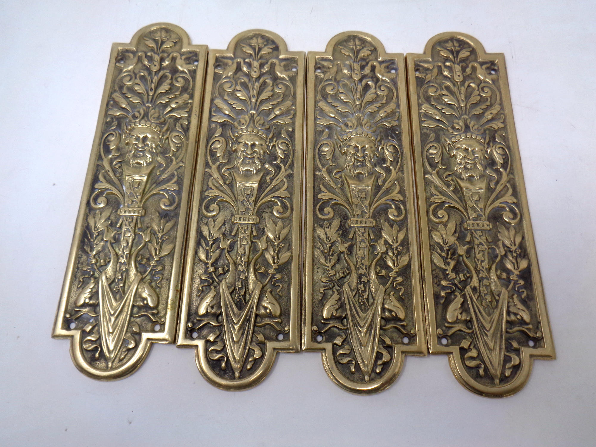 Two sets of four cast brass door plates
