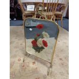 A brass mirrored fire screen with hand painted decoration