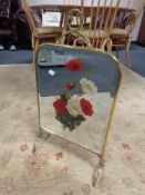A brass mirrored fire screen with hand painted decoration