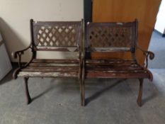 A pair of wooden slatted and cast iron garden chairs
