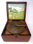 A 19th century walnut music box, disc diameter 23.5 cm.