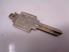 A solid silver door key