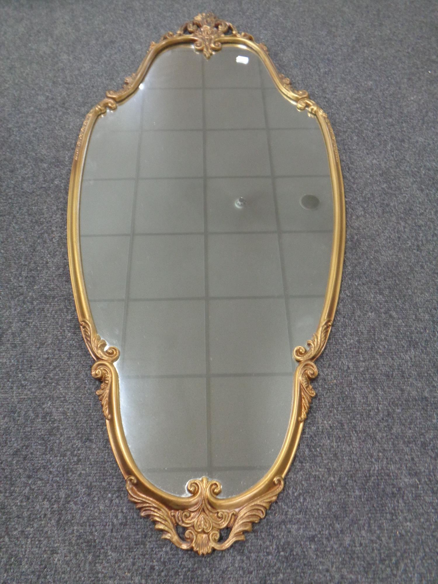 A decorative shaped gilt metal framed mirror