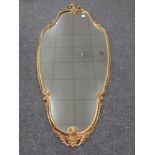 A decorative shaped gilt metal framed mirror