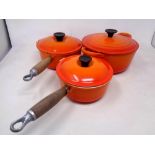 Two Le Creuset wooden handled pans with lids and a further casserole dish