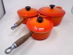 Two Le Creuset wooden handled pans with lids and a further casserole dish