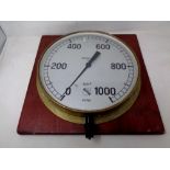 A circular air pressure gauge mounted on a board