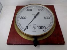 A circular air pressure gauge mounted on a board