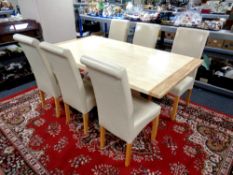 A contemporary faux marble dining table and six high back chairs upholstered in cream leather,
