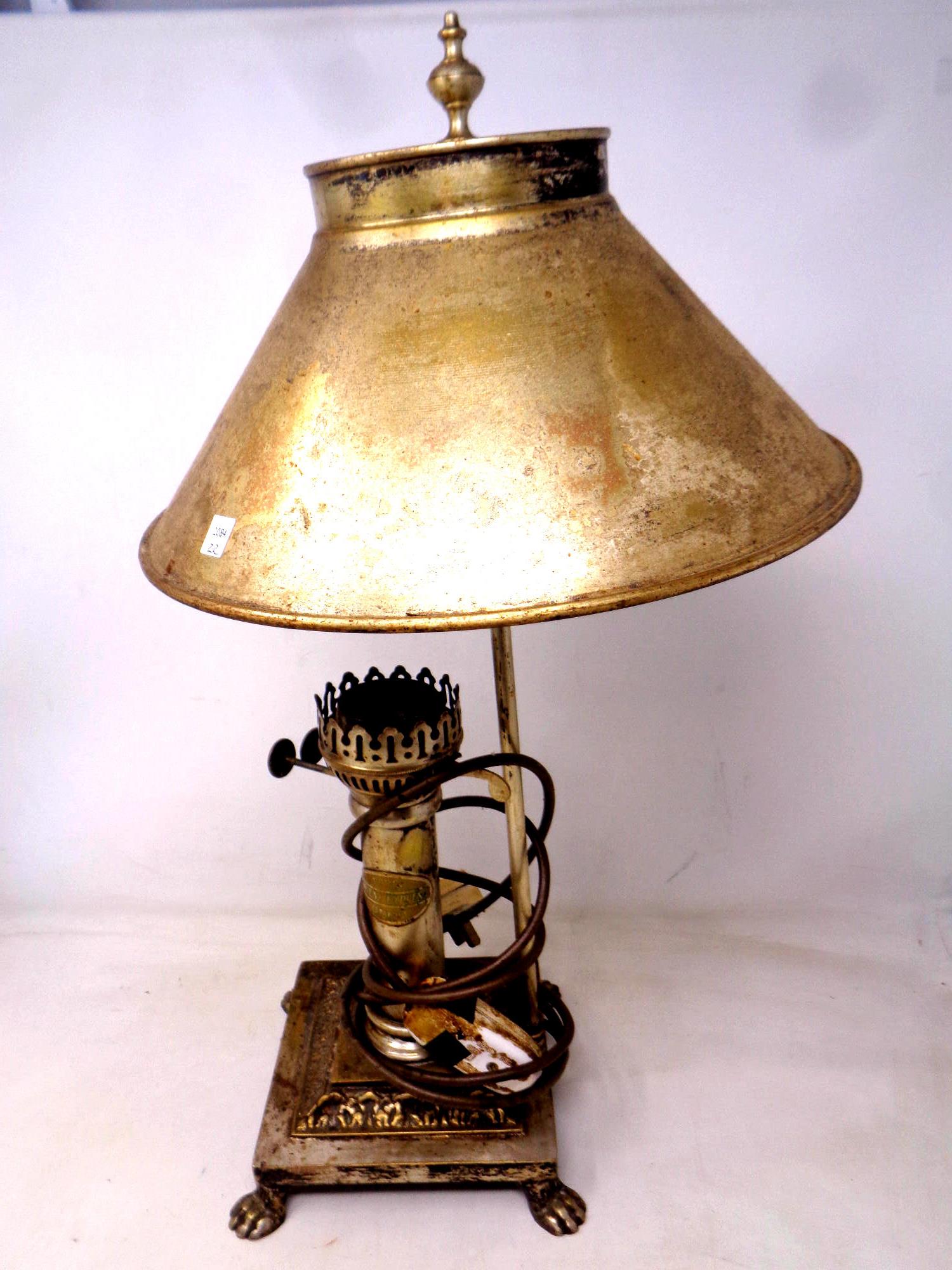 A brass retro style table lamp in the form of an oil lamp on paw feet.