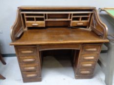 An Edwardian oak roll-topped double-pedestal desk.