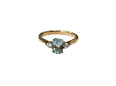 A 9ct yellow gold three stone diamond and aquamarine ring, size M.