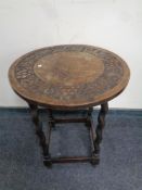 A circular carved oak occasional table on barley twist legs