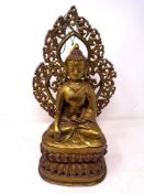 A brass figure of a seated Buddha on lotus throne