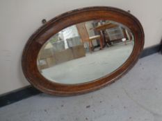 An Edwardian oval oak framed mirror