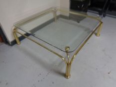 A large brass framed coffee table with plate glass top