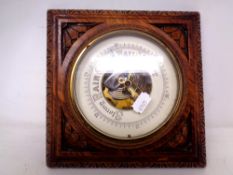 A wall barometer in carved oak case