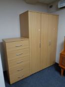 A contemporary wood effect wardrobe together with similar five drawer chest