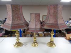 A set of three contemporary brass table lamps