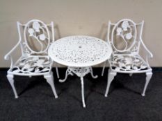 A painted metal circular patio table and a pair of armchairs