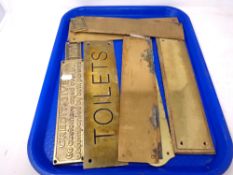 A tray of brass door signs and finger plates
