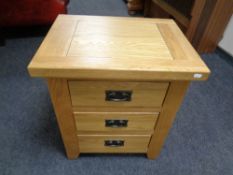 An oak three drawer bedside chest