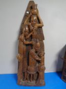 A 20th century African carved hardwood panel depicting figure combing a woman's hair