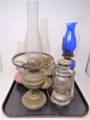 Five assorted oil lamps with chimneys