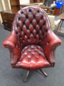 A Chesterfield oxblood leather buttoned back revolving office armchair