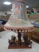 An Eastern wooden table lamp with tassel shade