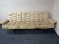 A mid 20th century cream leather three seater settee on chrome legs (distressed)