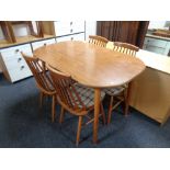 An oval kitchen table together with a set of four beech rail back chairs