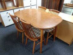 An oval kitchen table together with a set of four beech rail back chairs