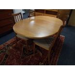 A 20th century teak G-Plan oval extending dining table together with a set of four rail back chairs