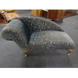 A contemporary chaise longue upholstered in a blue and gold fabric