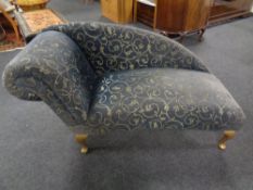 A contemporary chaise longue upholstered in a blue and gold fabric