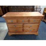 A contemporary pine seven drawer chest