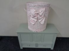 A painted oak blanket chest together with a wicker laundry basket