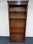 A set of open bookshelves in a mahogany finish