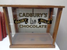 An early 20th century counter top display case bearing later Cadbury's advertising