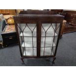 An Edwardian mahogany double door display cabinet on claw and ball feet